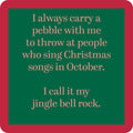 The Jingle Bell Rock Coaster by Drinks On Me features a green sign with a red border that reads: "I always carry a pebble with me to throw at people who sing Christmas songs in October. I call it my jingle bell rock." Perfect funny bar cart accessory or gift.