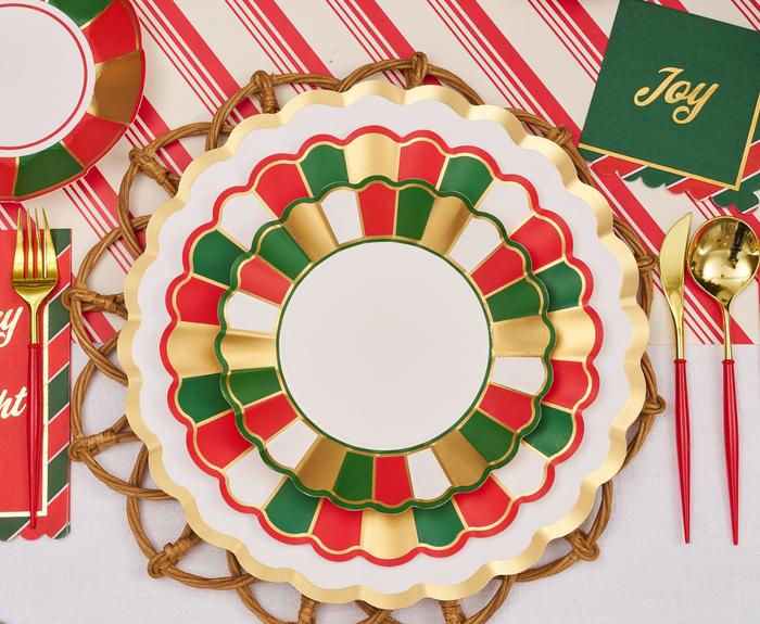 Create a joyful holiday table with Sophistiplate’s Joyful Christmas Salad Plates (8pk), layered over scalloped-edge red, green, and gold plates, gold cutlery, green napkins with "Joy" in gold, and a red-striped runner.