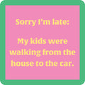 The Kids Walking Coaster by Drinks On Me features a pink square with a green border and yellow text: “Sorry I’m late—my kids were walking from the house to the car.” A funny bar cart accessory or hostess gift.