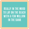 Text on a turquoise background with a beige border reads: "Lay on the beach with a few million in the bank"—perfect for housewarming gifts or as a funny drink coaster. Lay on Beach Coaster by Drinks On Me, in bold white letters.