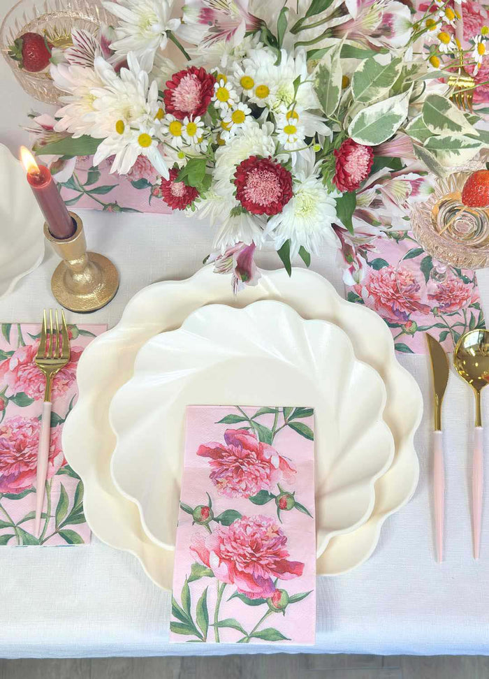 The Sophistiplate Love in Bloom Table Setting features a scallop-edged designer plate, pink floral napkin, gold cutlery, pink candle, and matching drink with a strawberry garnish for an elegant tablescape-in-a-box.