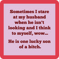 The Drinks On Me "Lucky Son of a Bitch Coaster" features a funny quote on pink with a red border—perfect for bar cart accessories or as a unique hostess gift.