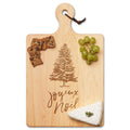 The Maple Maple Wood Cutting & Cheeseboard | Joyeux Noel | 16 x 10" features an engraved “Joyeux Noël” and tree design, beautifully presented with green grapes, crackers, and a wedge of cheese.