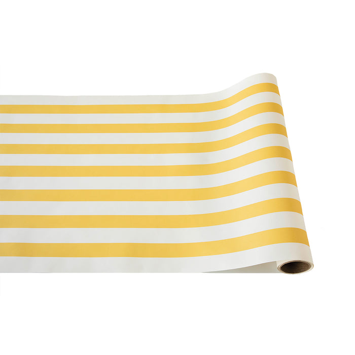 The Hester & Cook Marigold Classic Stripe Runner (20x25") features yellow and white stripes, perfect for gift wrapping or as a stylish table runner. Shown partially unrolled on a white background.