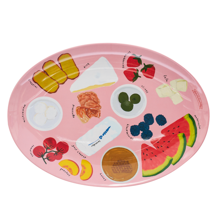 The Maple Meg Quinn Melamine Serving Tray is an oval pink tray featuring illustrations of bread, cheese, fruits, cured meat, olives, and honey. Dishwasher safe for easy cleaning.