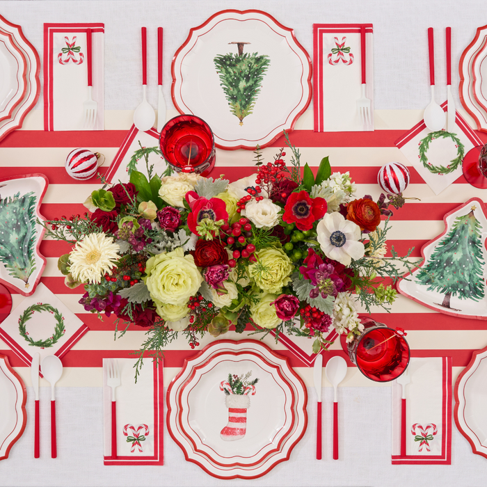 Create a festive holiday table setting with the Sophistiplate Merry and Bright Salad Plates (8pk), featuring charming Christmas designs. Paired with a red and white striped runner, a floral centerpiece, red cups, and neatly arranged utensils for eight guests, this disposable set makes cleanup quick and easy while adding joyful cheer to your celebration.