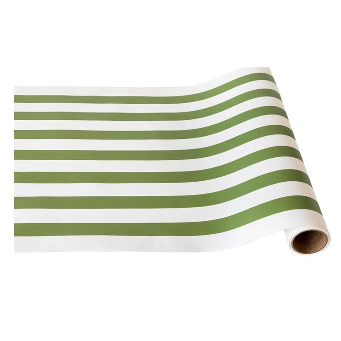 The Hester & Cook Moss Classic Stripe Runner (20x25") features alternating green and white stripes, ideal for gift wrapping or as a festive table runner, shown partially unrolled on a white surface.