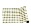 The Hester & Cook Moss Painted Check Runner (20" x 25') features a green and white checkered pattern, perfect for festive gift wrapping or as a decorative table runner. Shown partially unrolled on a white background.
