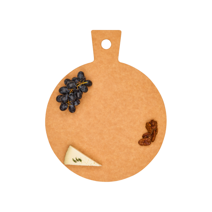 The Maple Natural Wood Composite Round Hostess Board with a handle holds black grapes, pecans, and a wedge of cheese near the edges, leaving its center empty.