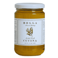 A glass jar of Bella Cucina Organic Acacia Honey from Piedmont, Italy, featuring a white label with a plant illustration and text. The jar has a white lid and contains golden biodynamic honey.