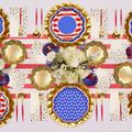 The Party in the USA Table Setting by Sophistiplate LLC includes gold-rimmed American flag plates, gold and red cutlery, patriotic napkins, and a white flower centerpiece—ideal for Fourth of July or as a party in a box.
