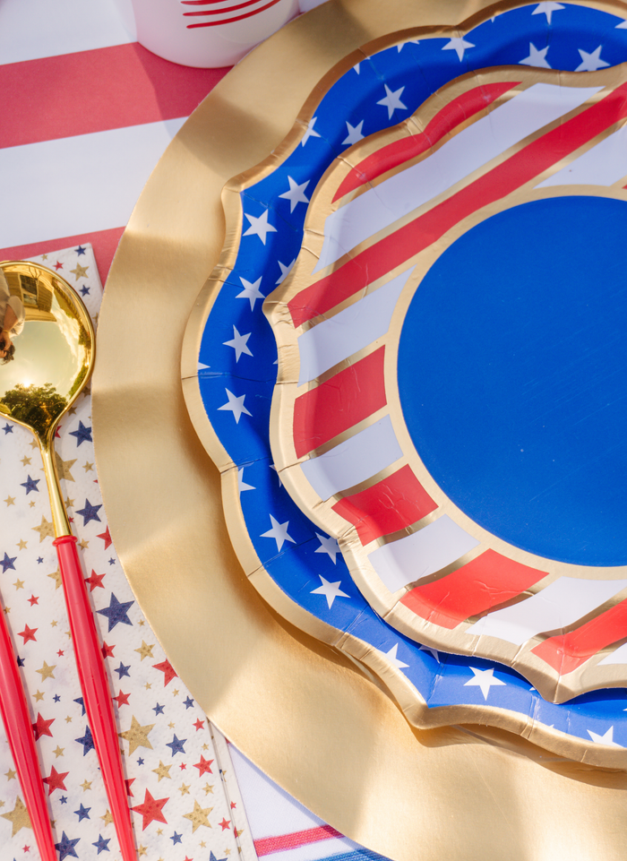The Sophistiplate LLC "4th of July Table for 16+: Party in the USA" set features patriotic star and stripe plates, red utensils, and star napkins for a festive, all-in-one party-in-a-box.