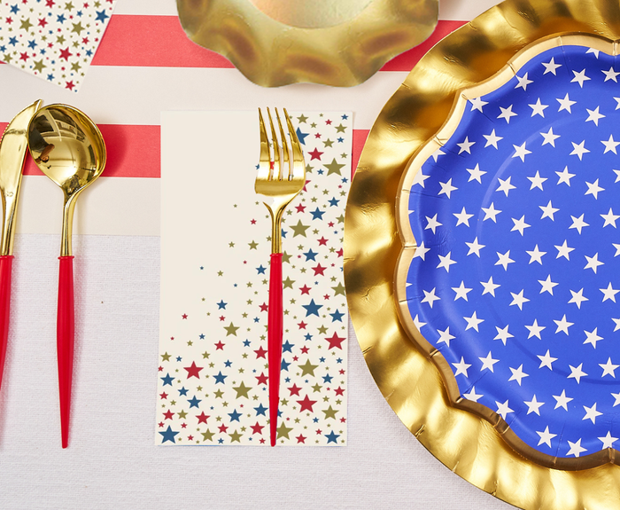 Create a festive table with Sophistiplate LLC's "4th of July Table for 16+: Party in the USA," featuring gold utensils, star-patterned plates, and multicolored star cards—perfect for a patriotic celebration with a party-in-a-box feel.