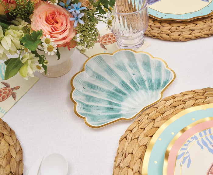 The Sophistiplate Pastel Sea Die Cut Shell Salad Plates (8pk) feature a green and white shell design—ideal for coastal parties, pairing beautifully with woven placemats, elegant utensils, and vibrant table décor.