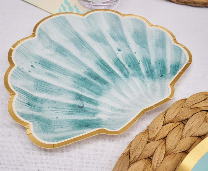 The Sophistiplate Pastel Sea Die Cut Shell Salad Plates (8pk) feature teal watercolor and a gold rim, shaped like seashells—ideal as decorative party plates for a coastal-themed table setting.