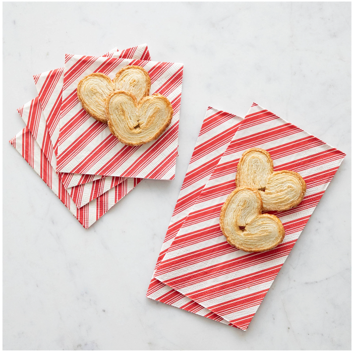 Three heart-shaped palmiers sit on Hester & Cook’s Peppermint Stripe Cocktail Napkins (20pk), displayed on a white marble surface.