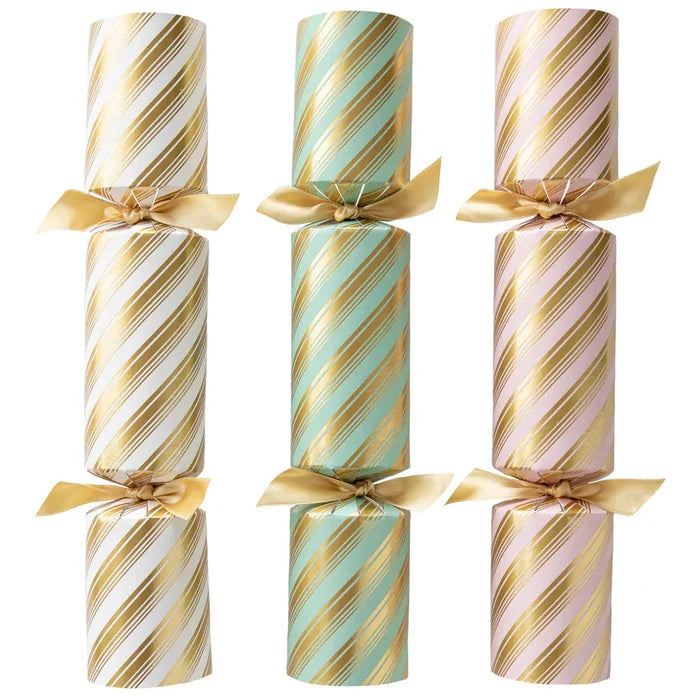 Hester & Cook’s Peppermint Stripe Crackers—three crackers in white, mint green, and pale pink with gold diagonal stripes—are tied with shiny gold ribbons and make perfect festive table decorations.