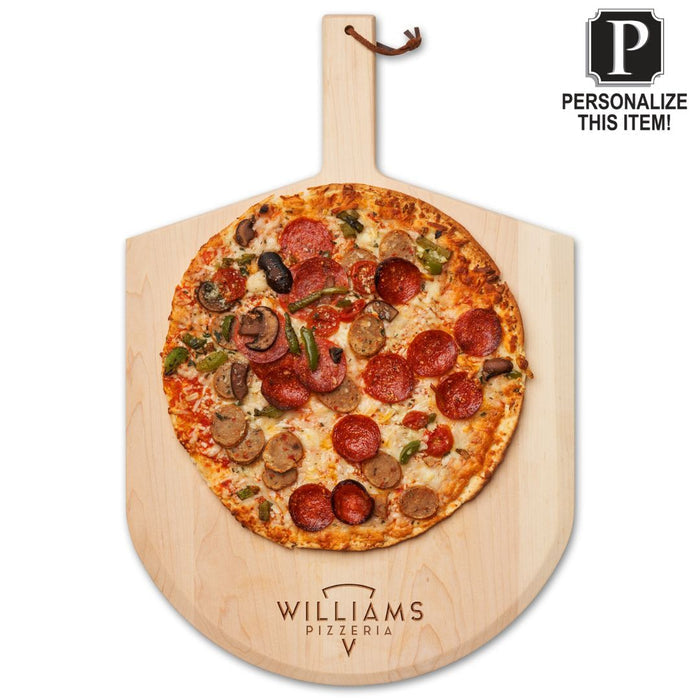 A handcrafted pizza rests on the Maple Personalized Maple Wood Pizza Peel 14 x 21". A sign reads: Personalize this item!.