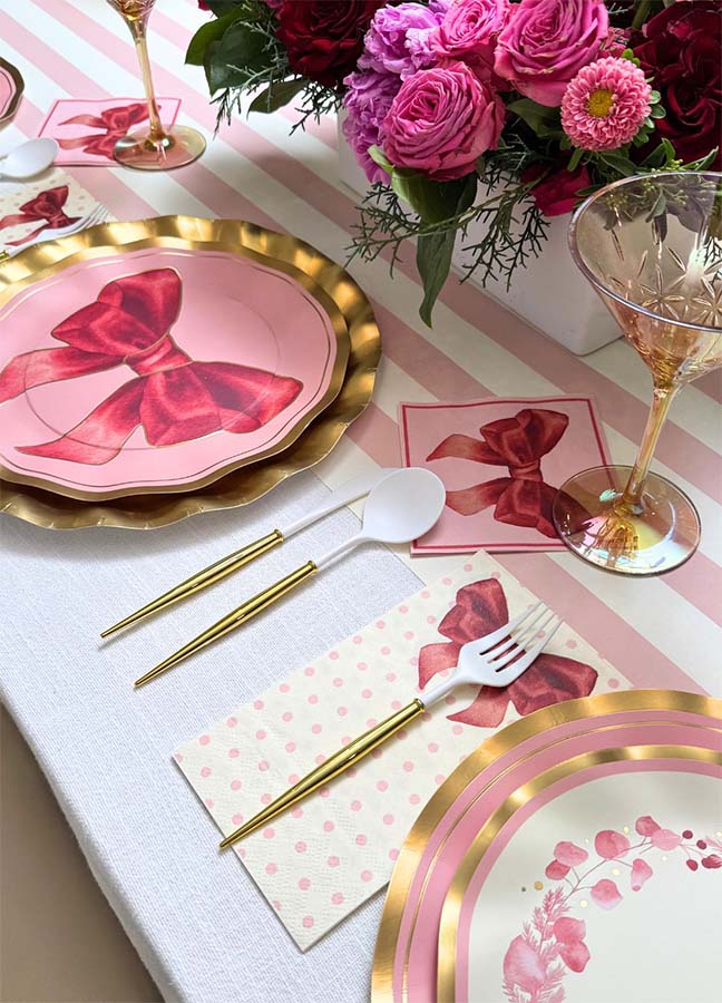 Create an elegant and festive atmosphere for your birthday party with Sophistiplate’s Pink Bows Dinner Plates (8-pack). This pink and gold table setting features bow-adorned plates from the Pink Bows Collection, coordinated napkins, matching glassware, and a stunning bouquet of pink and red flowers. Gold utensils and chic disposable party plates make it easy to celebrate in style while enjoying convenient cleanup.