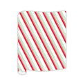 A sheet of wrapping paper with candy cane-like red, green, and white diagonal stripes—perfect for pairing with the Rosanne Beck Red & Green Striped Table Runner (20x12")—partially curled at one corner, on a white background.