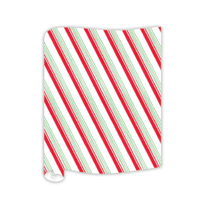 A sheet of wrapping paper with candy cane-like red, green, and white diagonal stripes—perfect for pairing with the Rosanne Beck Red & Green Striped Table Runner (20x12")—partially curled at one corner, on a white background.