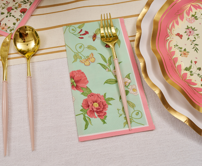 The Rococo Table Setting by Sophistiplate LLC features gold and pink utensils, a floral mint green napkin, and pink plates with gold rims on a white cloth with gold stripes—your perfect party-in-a-box look.