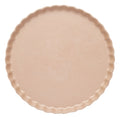 A round, light beige tart pan with a fluted edge is shown from above on a white background alongside Sophistiplate’s Simply Eco Dinner Plate- Sand/8pkg, perfect for sustainable baking and serving.