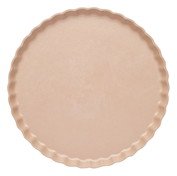 A round, light beige tart pan with a fluted edge is shown from above on a white background alongside Sophistiplate’s Simply Eco Dinner Plate- Sand/8pkg, perfect for sustainable baking and serving.