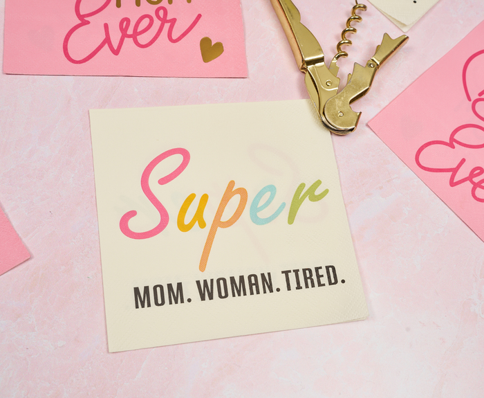 Sugarplum’s Super Mom Woman Tired Cocktail Napkins (26pk) feature “Super” in colorful script and “MOM. WOMAN. TIRED.” below—perfect for adding fun to your Mother’s Day party supplies display.
