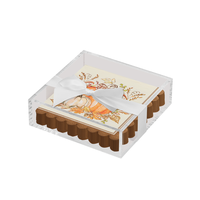 The Sophistiplate Thanksgiving Cocktail Napkin with Napkin Tray features a clear acrylic tray holding scalloped-edge napkins decorated with pumpkins, leaves, and berries, tied with a white satin ribbon—ideal for modern fall tablescapes.