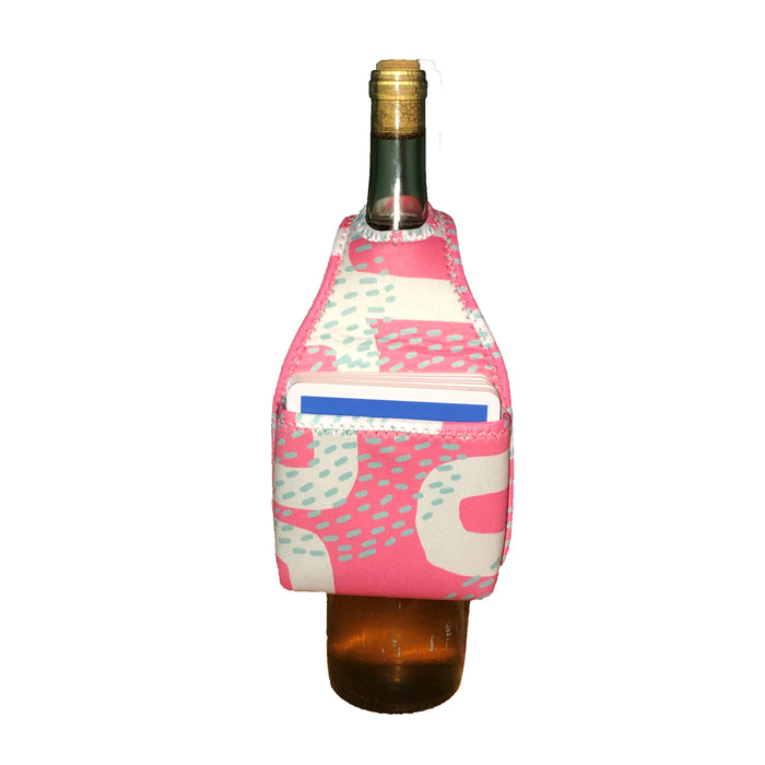 The HOOK-r by Drinks On Me is a wine bottle accessory: a pink and white patterned neoprene sleeve with a front pocket holding a blue and white card, displayed against a white background.