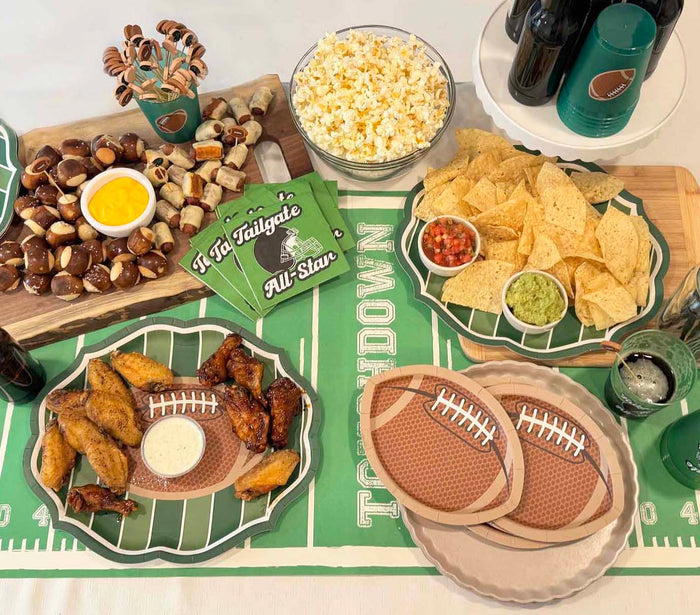 The Superbowl Set by Sophistiplate includes wings, chips with salsa and guacamole, popcorn, pretzel bites, beers, designer disposable plates, a field-themed tablecloth, and “It’s Tailgate time All-Star” napkins—your perfect football party-in-a-box!.
