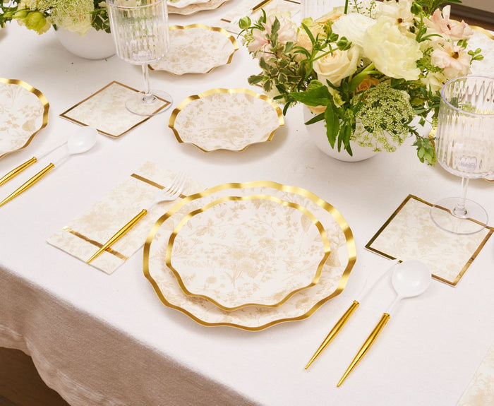 Create a light and luxurious table with Sophistiplate's Timeless Sand Salad Plates (8pk), paired with gold utensils, clear glasses, white napkins, and floral centerpieces on a white tablecloth—perfect for formal occasions.
