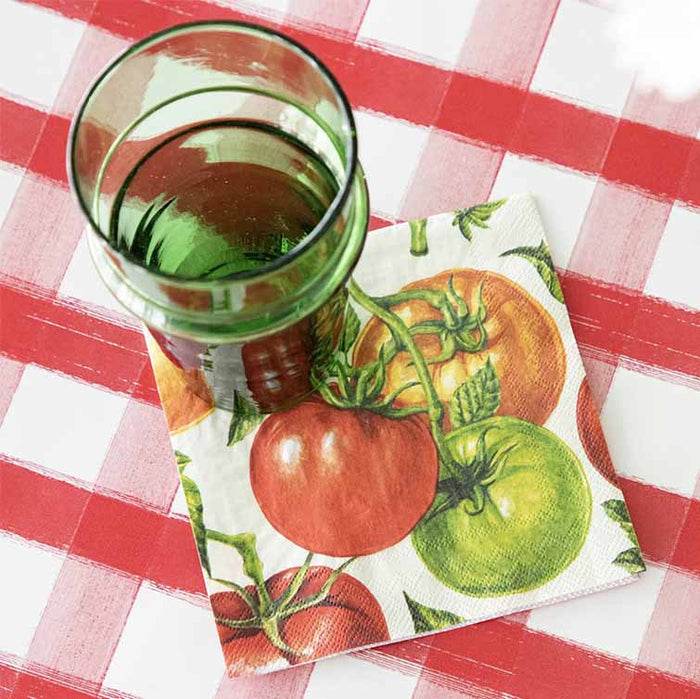 A green glass of water sits on Hester & Cook's Tomato Cocktail Napkin (pack of 20), atop a red and white checkered tablecloth.