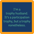 The Drinks On Me Trophy Coaster features a blue square with an orange border and the phrase “I’m a trophy husband. It’s a participation trophy, but a trophy nonetheless”—a fun addition to any bar cart or quirky housewarming gift.