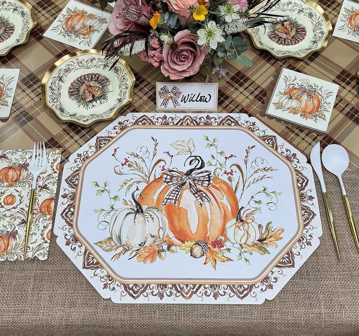 Create a festive autumn table with Rosanne Beck Turkey & Gourds Placemat/10pk, disposable tableware, utensils, a plaid tablecloth, a floral centerpiece, and a “Willow” name card.