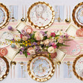 Create a festive Easter table for 16 with Sophistiplate LLC’s Ultimate Easter Tablescape: charming bunny plates, gold cutlery, floral napkins, pink glassware, and a spring centerpiece accented by decorated eggs.