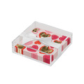 The Sophistiplate Valentines Day Cocktail Napkin with Napkin Tray holds heart-printed napkins in pink, red, and gold, tied with a white ribbon—an elegant touch to any modern tabletop.
