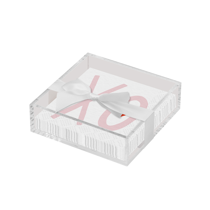 The Sophistiplate Valentines Day Cocktail Napkin with Napkin Tray is a modern acrylic tray holding white napkins with pink "XO" text and a white ribbon bow, perfect as a festive tabletop accent.