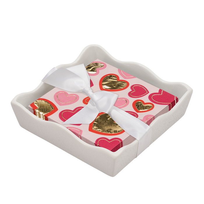 The Sophistiplate Valentines Day Cocktail Napkin with Napkin Tray features a white ceramic tray and napkins adorned with pink and gold hearts, tied with a white satin ribbon—ideal for a chic, modern tabletop.