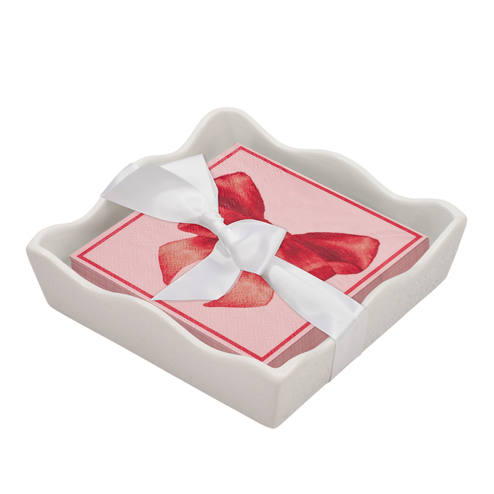 The Sophistiplate Valentines Day Cocktail Napkin with Napkin Tray features pink napkins with a red bow and white ribbon, displayed in a white ceramic holder for a stylish accent to your modern table.