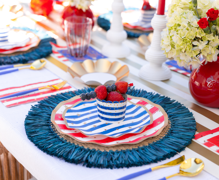 Create a festive 4th of July table with Sophistiplate LLC’s "4th of July Table for 16+: Patriotic Confetti"—red, white, and blue plates, gold utensils, party cups, vases, candlesticks, and fresh flowers for patriotic flair.