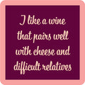 The Wine Pairing Coaster by Drinks On Me is a maroon square with a light pink border and cursive text: I like a wine that pairs well with cheese and difficult relatives—perfect as a funny housewarming or bar cart gift.