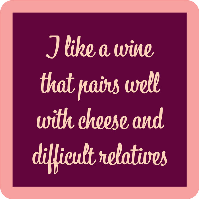 The Wine Pairing Coaster by Drinks On Me is a maroon square with a light pink border and cursive text: I like a wine that pairs well with cheese and difficult relatives—perfect as a funny housewarming or bar cart gift.