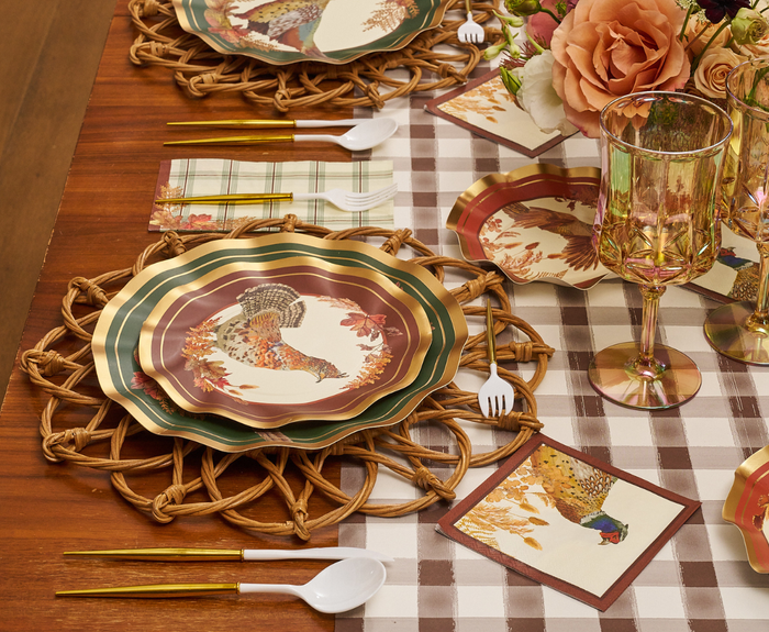 Sure! Here’s the rewritten sentence using the given product data: A fall-themed table setting featuring Sophistiplate Woodland Harvest Salad Plates (8-pack) with turkey patterns, gold utensils, wicker placemats, plaid napkins, glass goblets, and floral centerpieces atop a checkered table runner.