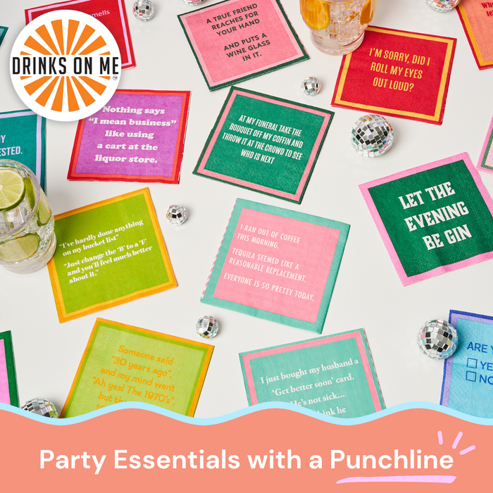 Piss Off Teenager Napkins by Drinks On Me are scattered on a white table with mini disco balls and drinks, featuring the text “DRINKS ON ME” and “Party Essentials with a Punchline.”.
