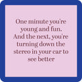 A pink square with a dark blue border displays “One minute you’re young and fun. And the next, you’re turning down the stereo to see better” in brown font. Add laughs to your table with Drinks On Me’s Coaster Bundle: Best Sellers—perfect for parties!.