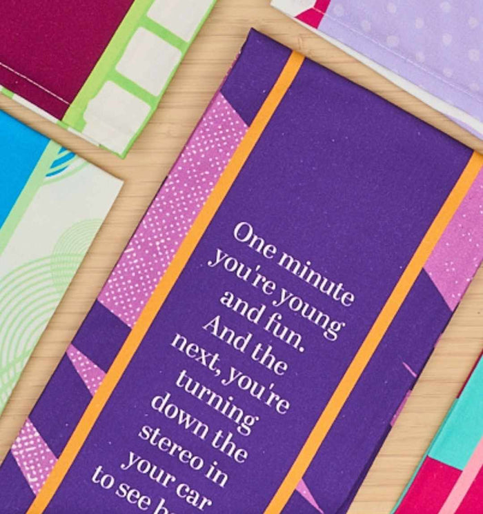 A close-up of the Young and Fun Dish Towel by Drinks On Me, featuring the witty quote: One minute you’re young and fun. And the next, you’re turning down the stereo in your car to see better—a perfect humorous kitchen gift.
