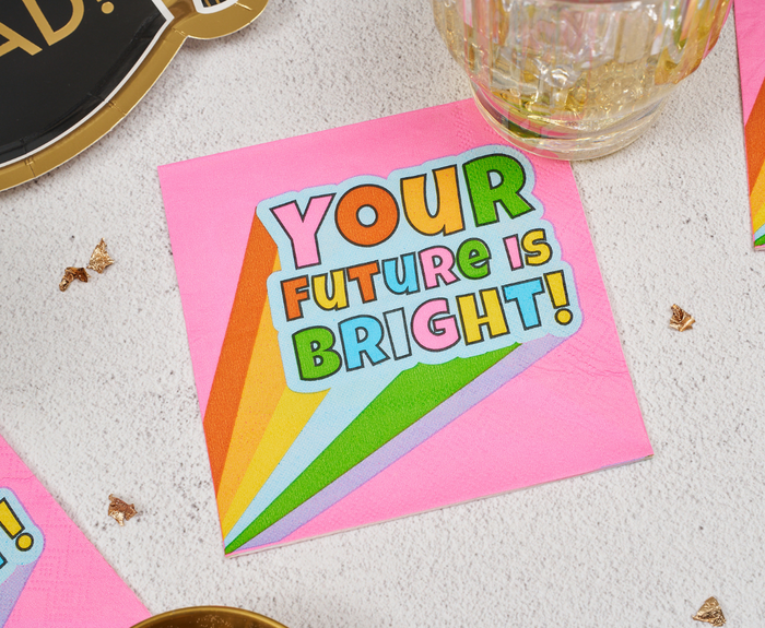 Sugarplum's "Your future is bright" Cocktail Napkins (26pk) feature a pink background, rainbow design, and bold text—ideal for adding a festive touch to your graduation celebration.